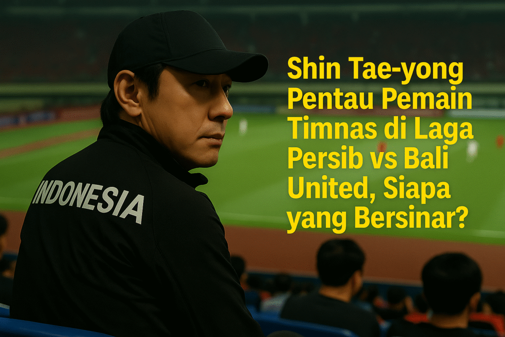 Shin Tae-yong duduk di tribun stadion sambil memantau pertandingan Persib vs Bali United dengan serius, mengenakan jaket bertuliskan INDONESIA